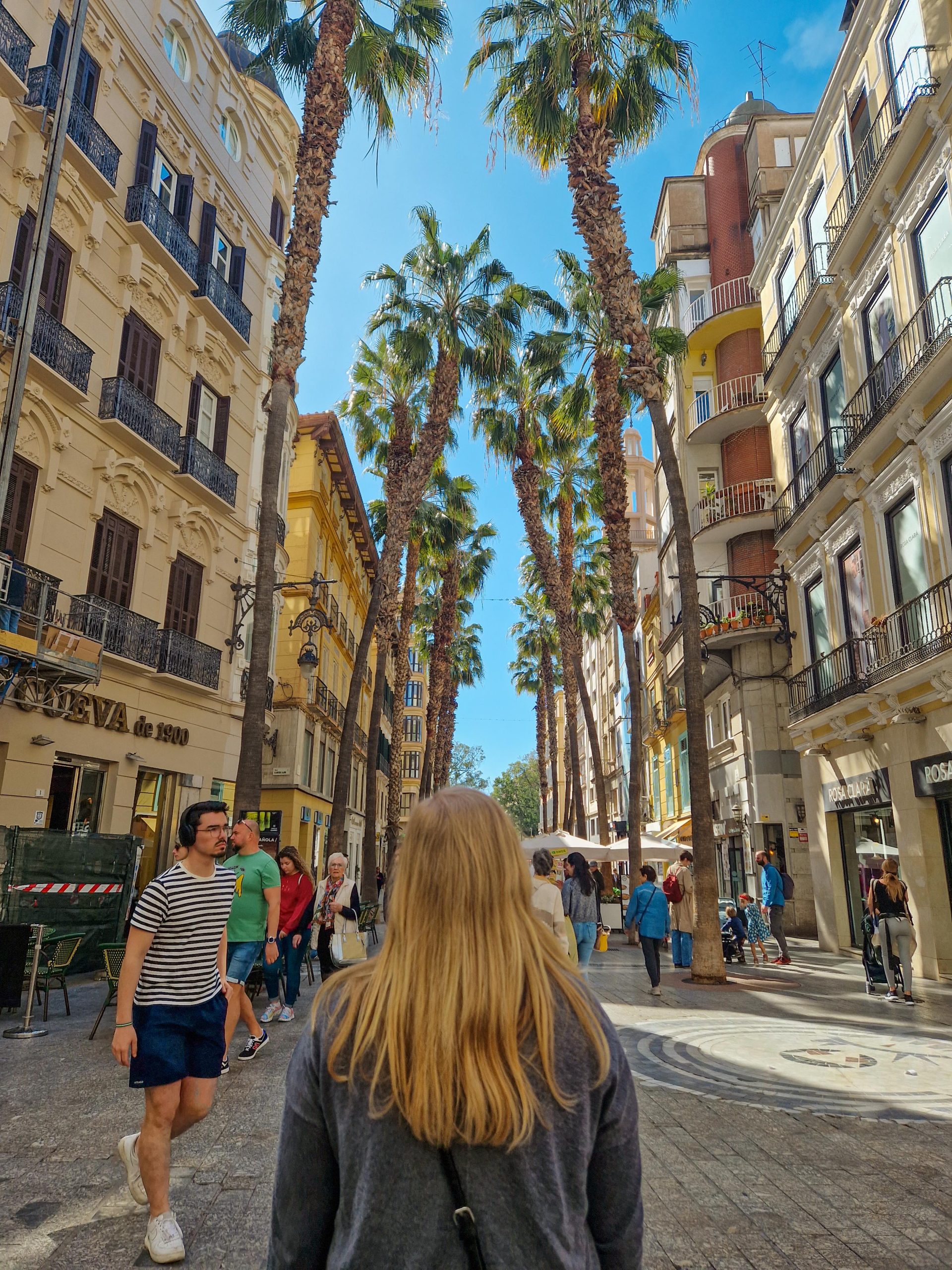 Frau in einer Palmen gesäumten Straße in Malaga