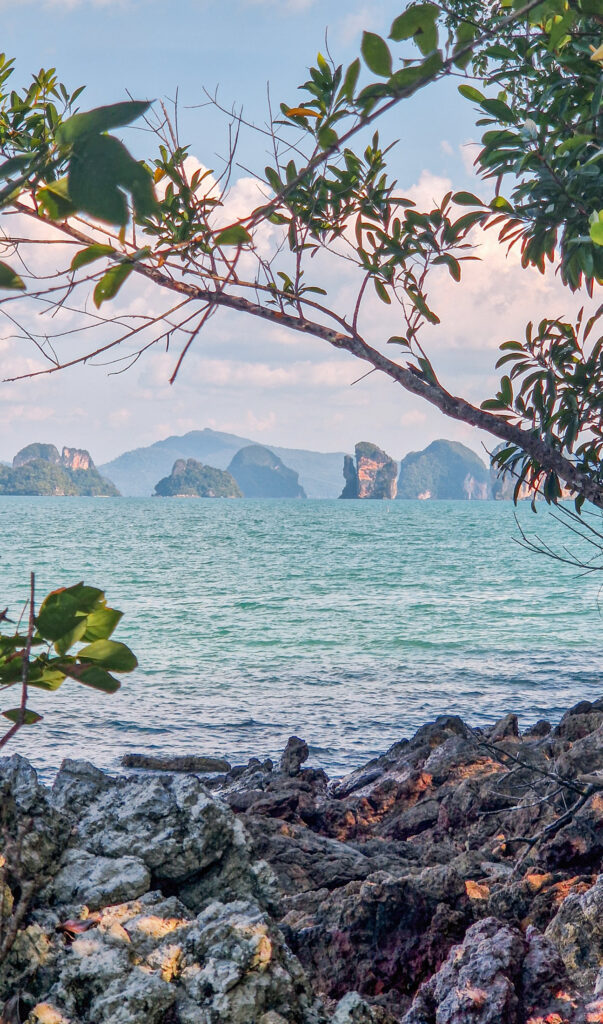 Felsige Küste auf Koh Yao Noi mit Blick auf die Kalksteinfelsen der Phang-Nga-Bucht, Thailand